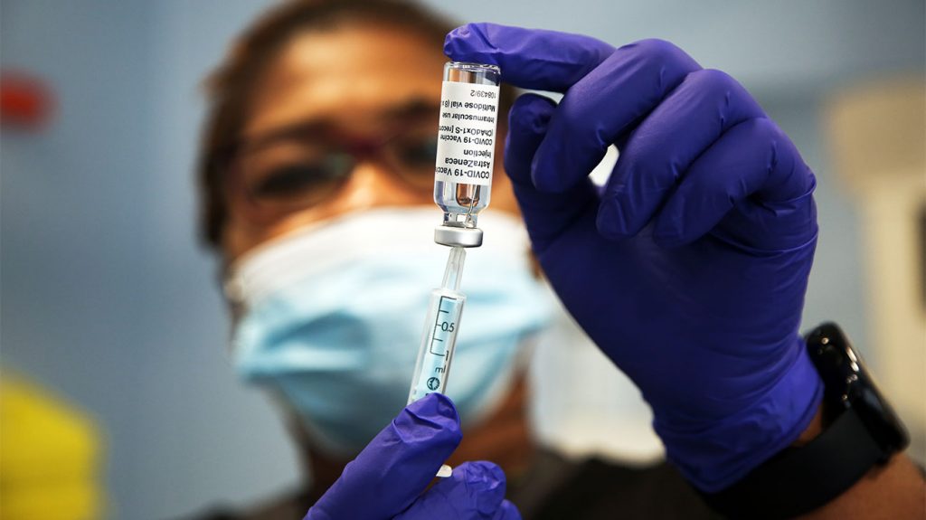 Zdravotnický pracovník se připravuje na podání vakcíny Oxford / AstraZeneca COVID-19 veřejnosti v očkovacím středisku v severním Londýně