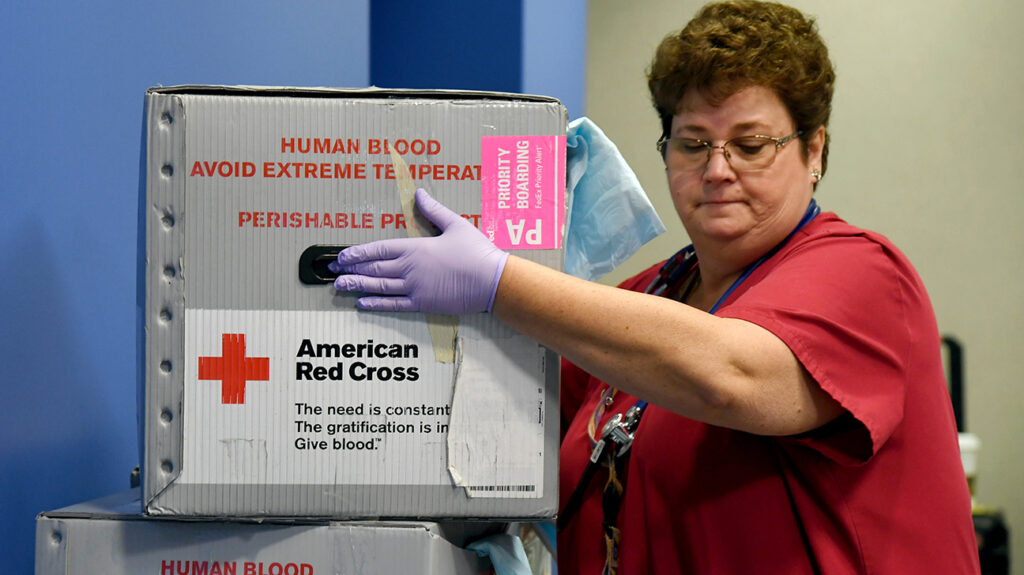 Ketua pasukan Palang Merah Amerika Eva Klappa membawa kotak pengangkutan untuk darah yang didermakan semasa pacuan darah Palang Merah Amerika untuk membantu mengurangkan kekurangan bekalan darah akibat wabak koronavirus di Las Vegas Motor Speedway pada 27 Mac 2020 di Las Vegas, Nevada.