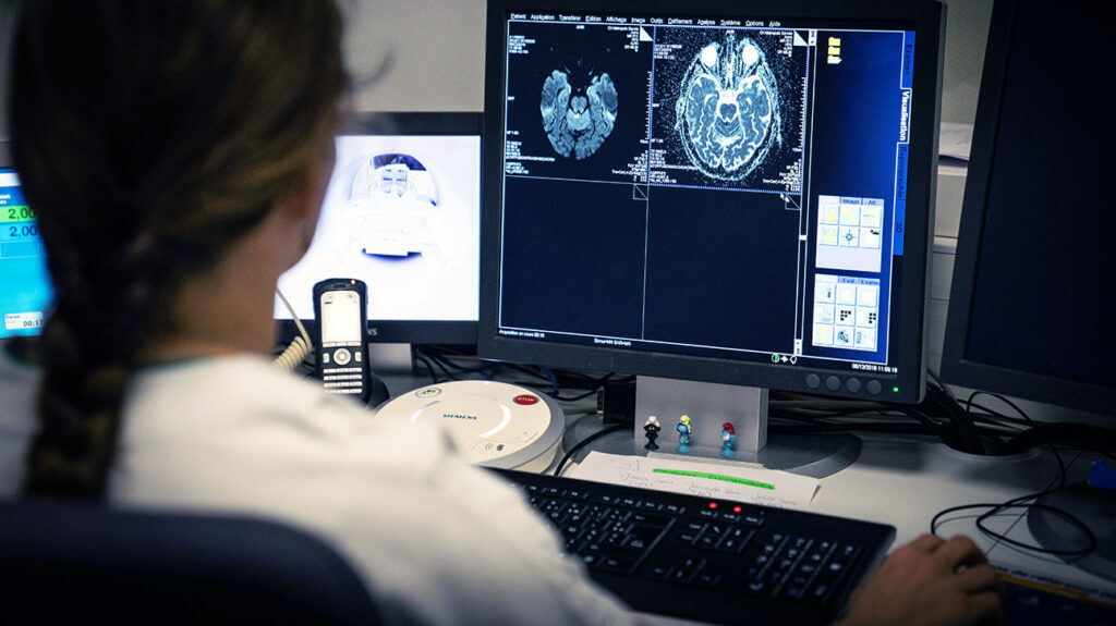 Een onderzoeker of medisch professional kijkt naar beelden van een hersenscan